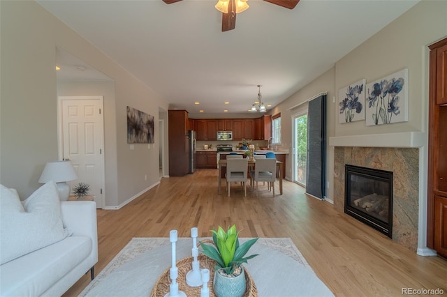 2908 Open Sky Way, Castle Rock, CO 80109 - living room with light wood-style flooring, ceiling fan, a chandelier, a high end fireplace, and recessed lighting
