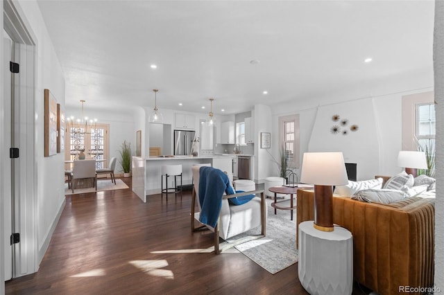 living room with plenty of natural light, dark hardwood / wood-style floors, and a chandelier