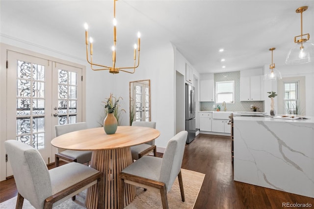 dining space featuring french doors, sink, and dark wood-type flooring