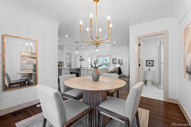 dining area with an inviting chandelier and dark hardwood / wood-style flooring