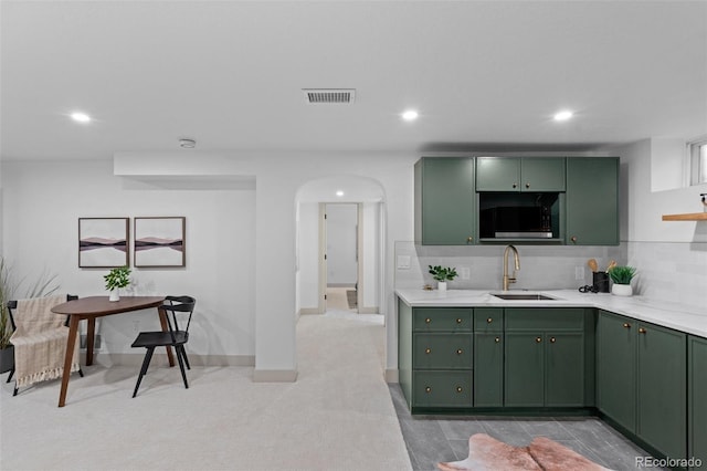 kitchen with tasteful backsplash, sink, and green cabinetry