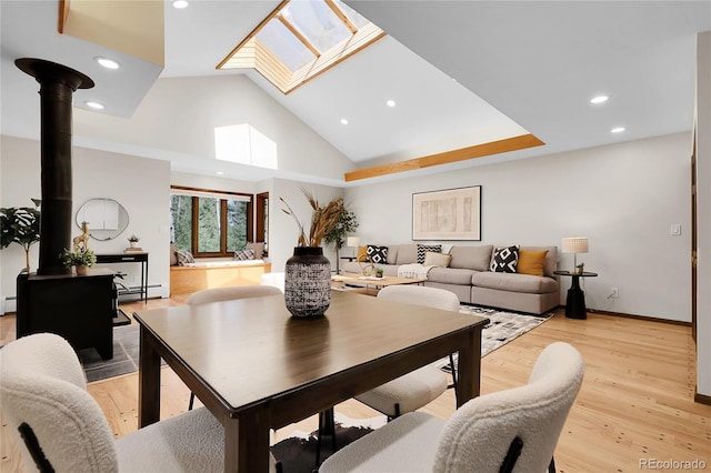 8782 S Ault Ln, Morrison, CO 80465 - living area with a baseboard radiator, a skylight, recessed lighting, light wood finished floors, and high vaulted ceiling
