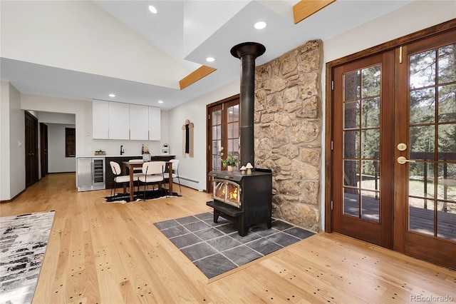 8782 S Ault Ln, Morrison, CO 80465 - interior space featuring light wood-style floors, a wood stove, baseboard heating, wine cooler, and recessed lighting