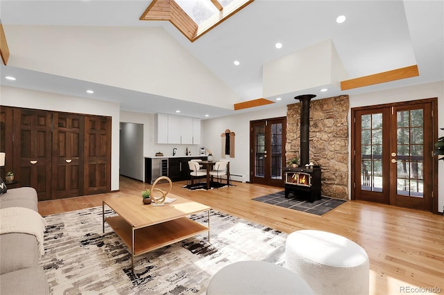 8782 S Ault Ln, Morrison, CO 80465 - living area with french doors, a wood stove, high vaulted ceiling, light wood finished floors, and recessed lighting