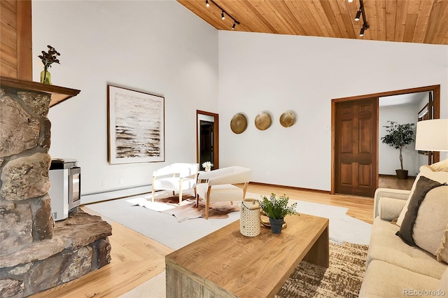 8782 S Ault Ln, Morrison, CO 80465 - living room featuring track lighting, wood ceiling, wood finished floors, a baseboard heating unit, and baseboards