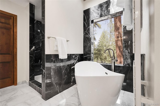 8782 S Ault Ln, Morrison, CO 80465 - bathroom with marble tiled flooring, tile walls, a freestanding tub, and walk in shower