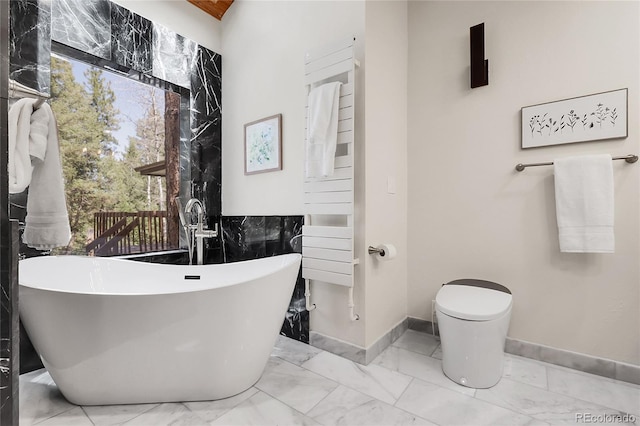 8782 S Ault Ln, Morrison, CO 80465 - full bath with marble look tile flooring, baseboards, a soaking tub, and toilet