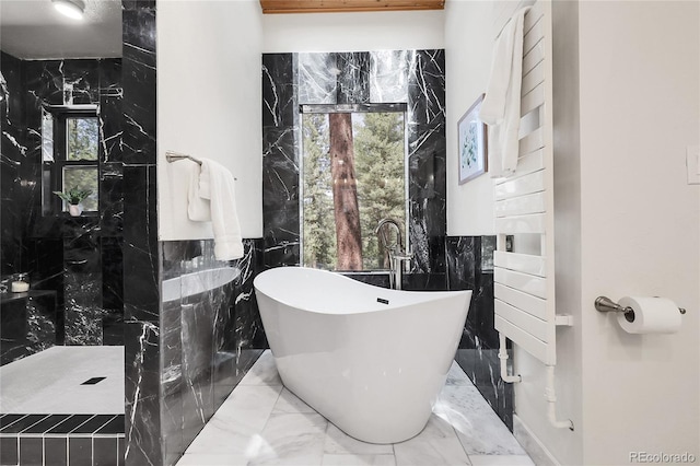 8782 S Ault Ln, Morrison, CO 80465 - full bathroom with marble tiled flooring, tile walls, a freestanding tub, a walk in shower, and plenty of natural light