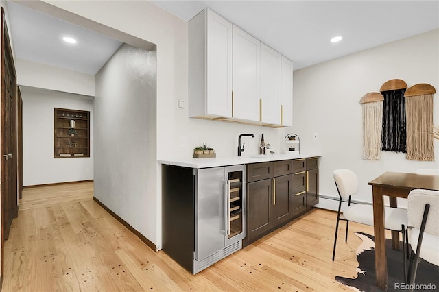8782 S Ault Ln, Morrison, CO 80465 - indoor wet bar with light wood finished floors, beverage cooler, recessed lighting, and baseboards