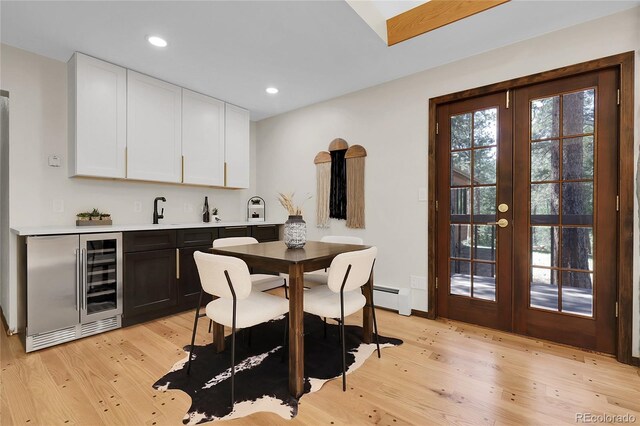8782 S Ault Ln, Morrison, CO 80465 - indoor wet bar featuring beverage cooler, french doors, a baseboard heating unit, light wood finished floors, and recessed lighting