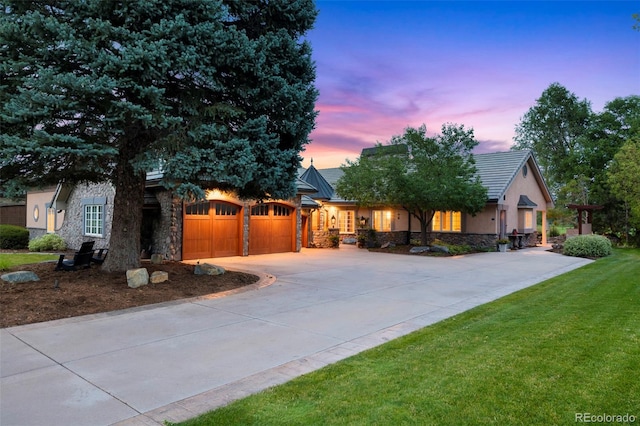 view of front of home featuring a garage, stone siding, a front lawn, and concrete driveway