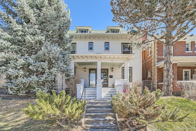 view of front of home with brick siding and a porch