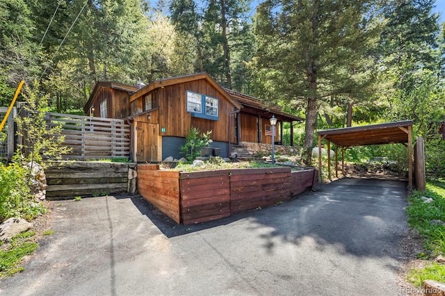 41 Silver Spruce, Boulder, CO 80302 - view of front of home featuring asphalt driveway, a detached carport, fence, and an outdoor structure