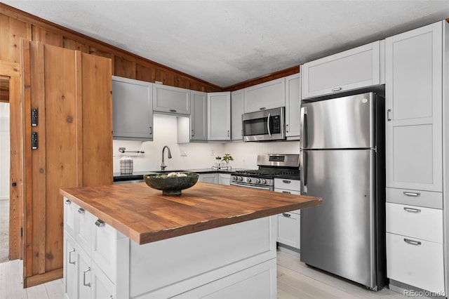 41 Silver Spruce, Boulder, CO 80302 - kitchen with appliances with stainless steel finishes, butcher block countertops, lofted ceiling, a sink, and a center island