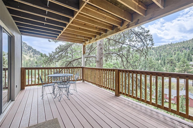 wooden terrace with a wooded view