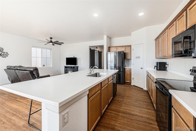 kitchen featuring light countertops, a sink, and black appliances