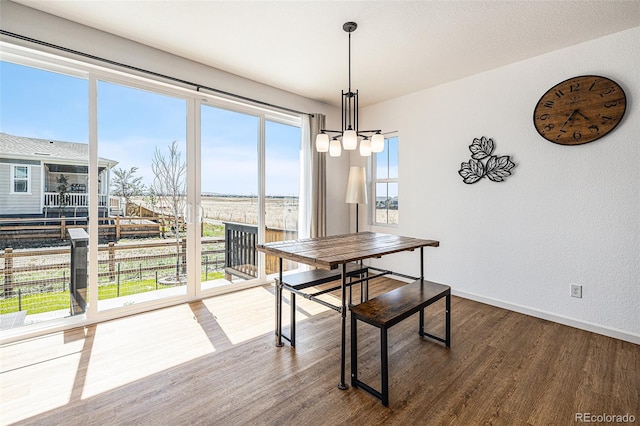 dining room with an inviting chandelier and dark wood-type flooring