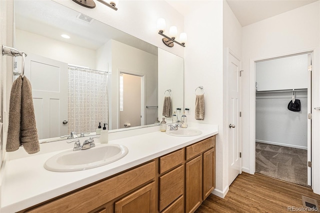 bathroom with hardwood / wood-style flooring, vanity, and walk in shower