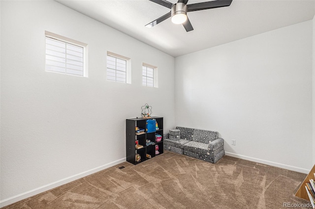 living area featuring ceiling fan and carpet flooring