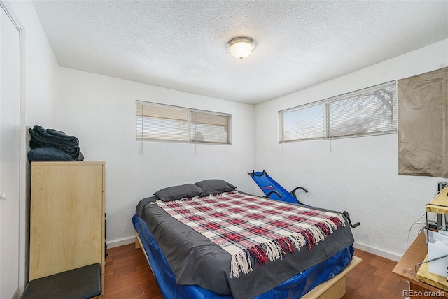 bedroom with dark wood-type flooring and a textured ceiling