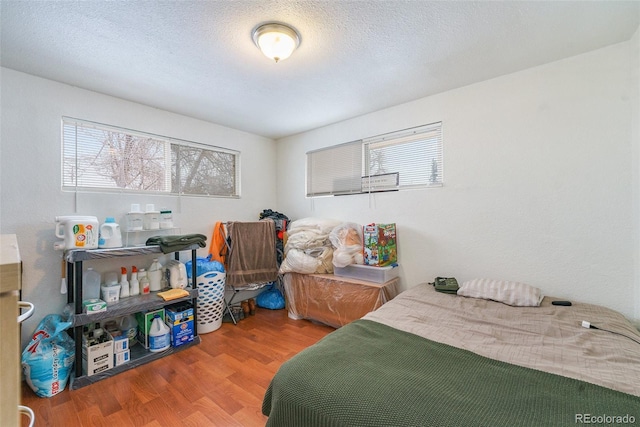 bedroom with wood-type flooring and a textured ceiling