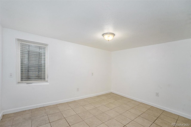 spare room with light tile patterned floors and a textured ceiling