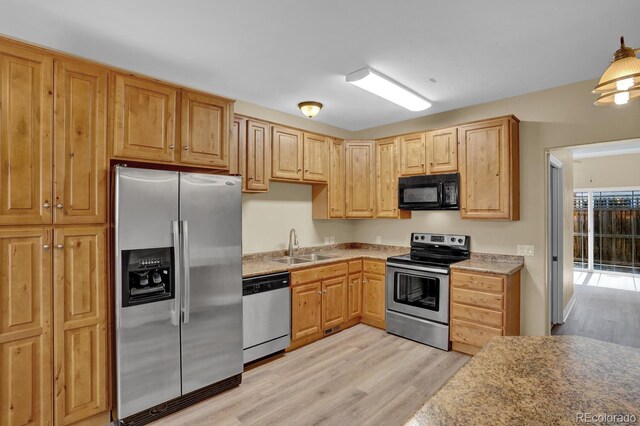 kitchen featuring appliances with stainless steel finishes, light brown cabinets, sink, and light hardwood / wood-style floors