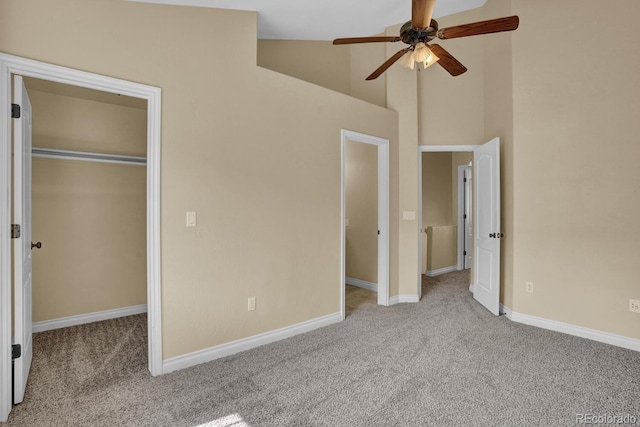 unfurnished bedroom with a closet, ceiling fan, high vaulted ceiling, and light colored carpet