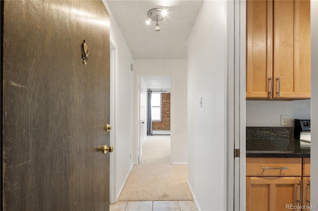 850 20th St Unit 201, Boulder, CO 80302 - hallway with baseboard heating, light carpet, baseboards, a textured ceiling, and light tile patterned floors