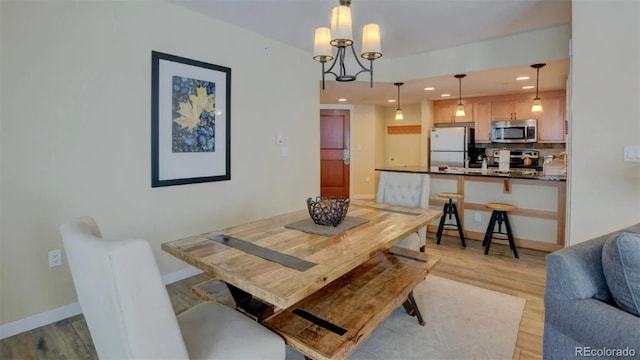 dining room featuring a notable chandelier and light hardwood / wood-style flooring