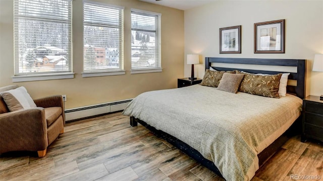 bedroom featuring wood-type flooring and baseboard heating