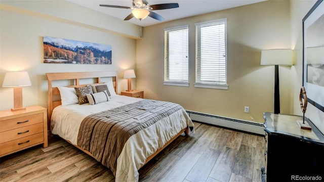 bedroom featuring hardwood / wood-style floors, ceiling fan, and baseboard heating