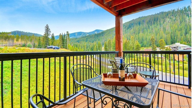 wooden deck featuring a mountain view and a yard