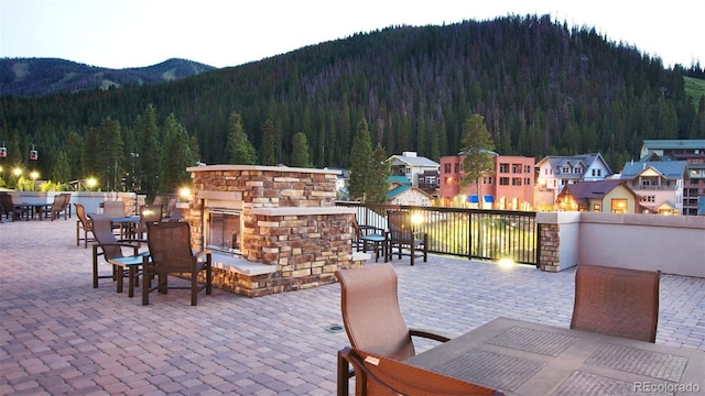 view of patio with a mountain view and an outdoor stone fireplace