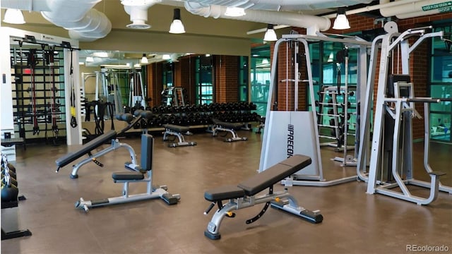 exercise room featuring brick wall