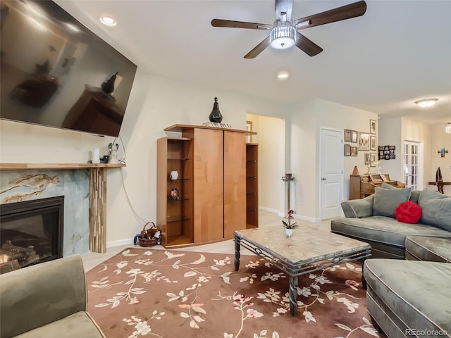 living room featuring ceiling fan and a fireplace