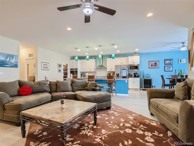 living room with light hardwood / wood-style floors, wine cooler, and ceiling fan