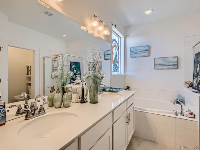 bathroom featuring shower with separate bathtub, vanity, and tile patterned floors