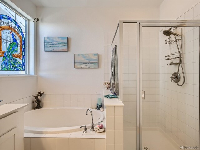 bathroom featuring shower with separate bathtub, vanity, and a healthy amount of sunlight