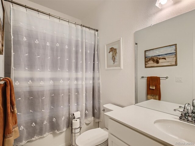 bathroom with a shower with shower curtain, vanity, and toilet