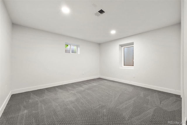 spare room featuring dark colored carpet