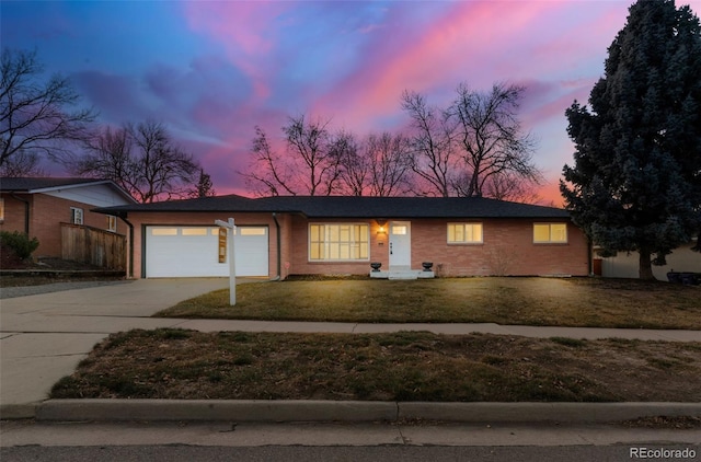 ranch-style house featuring a garage and a yard