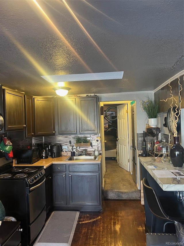 kitchen with sink, a textured ceiling, black appliances, and dark hardwood / wood-style flooring