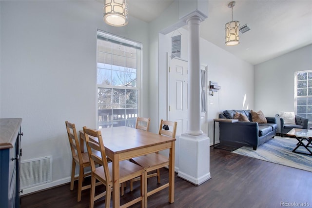 dining area featuring lofted ceiling, ornate columns, and dark hardwood / wood-style flooring