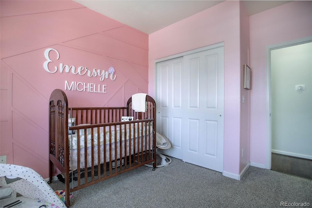 bedroom featuring a crib, carpet floors, and a closet