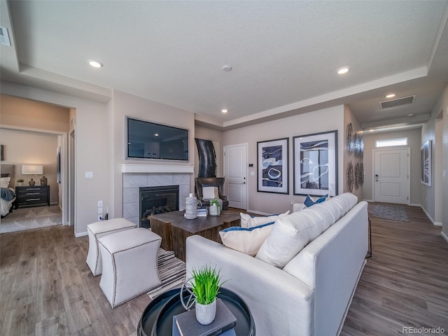 living room featuring light hardwood / wood-style floors and a tiled fireplace