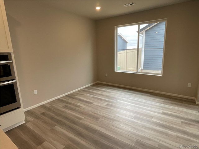 unfurnished dining area featuring light wood-style floors, visible vents, baseboards, and recessed lighting