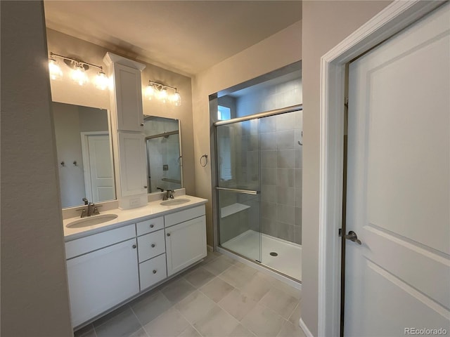 bathroom featuring tile patterned floors, double vanity, a stall shower, and a sink