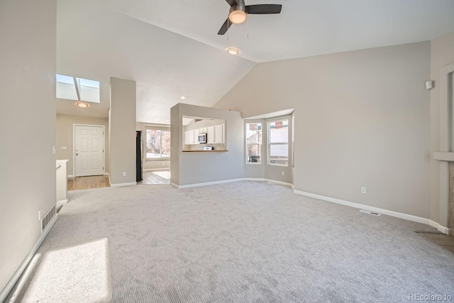 unfurnished living room with lofted ceiling, ceiling fan, plenty of natural light, and light carpet