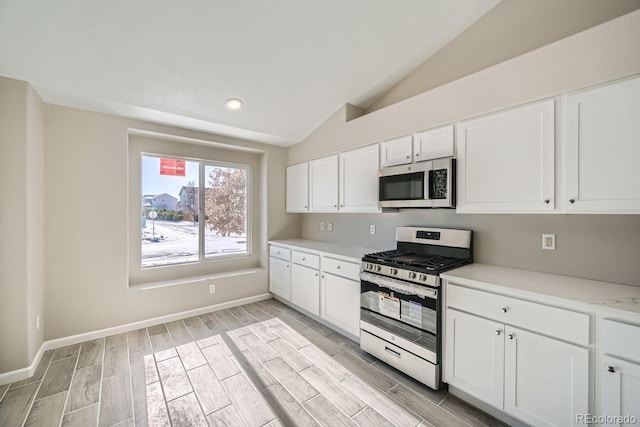 kitchen featuring white cabinetry, lofted ceiling, and stainless steel appliances